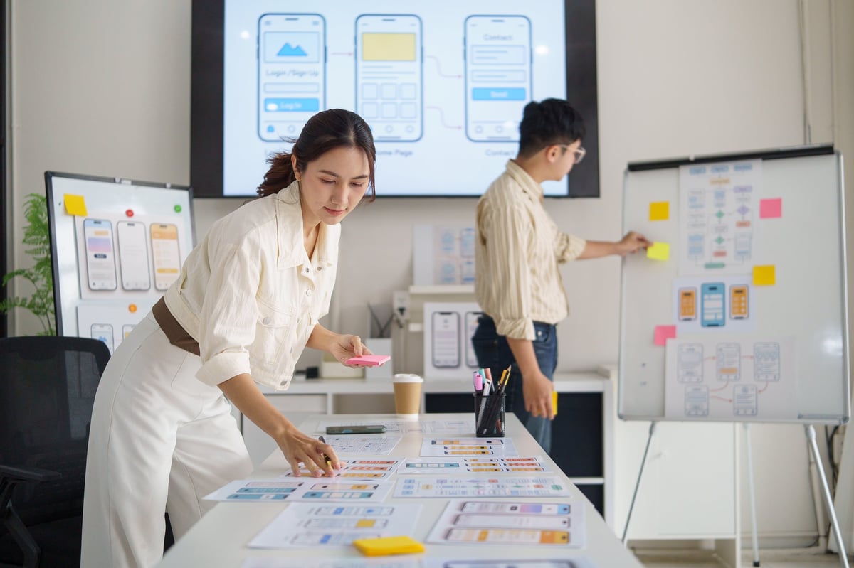 Designer planning a mobile interface with sticky notes