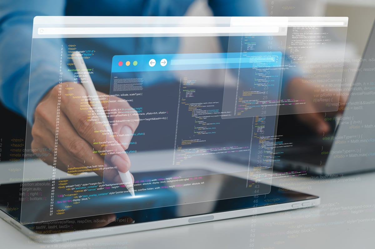 Close-up of hands working on a tablet with a code interface